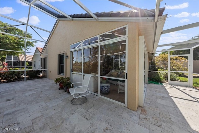 view of patio featuring glass enclosure