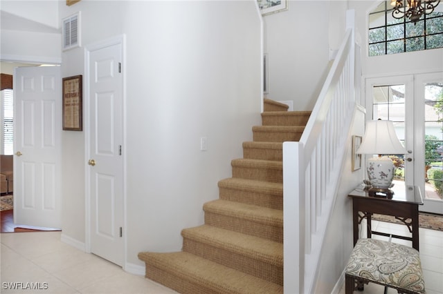 stairway with a high ceiling and an inviting chandelier