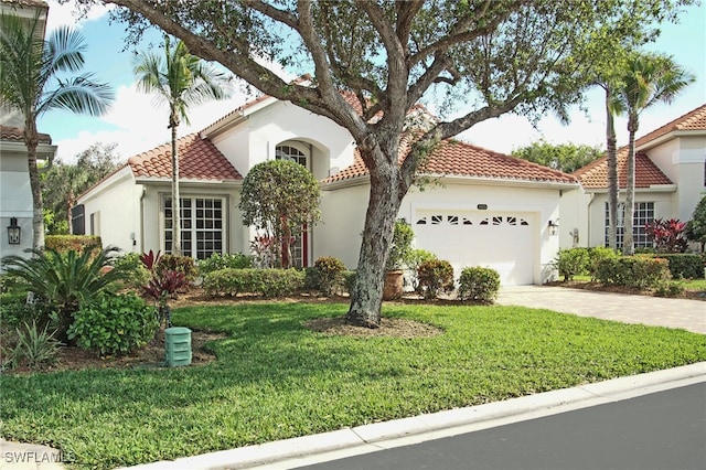 mediterranean / spanish-style home featuring a front yard and a garage