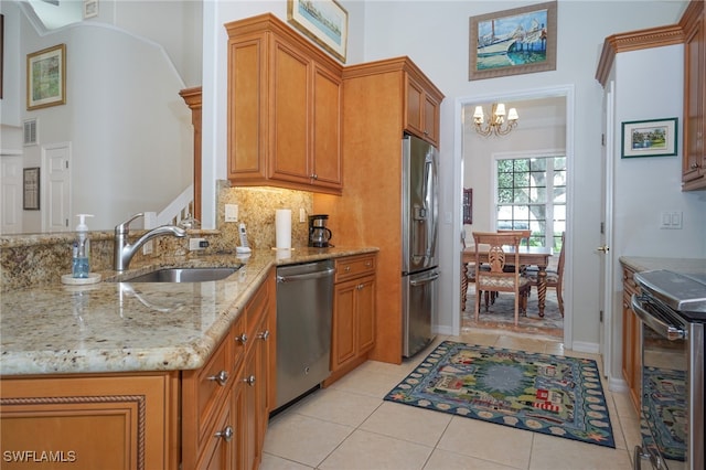 kitchen with sink, light stone countertops, light tile patterned floors, a notable chandelier, and stainless steel appliances