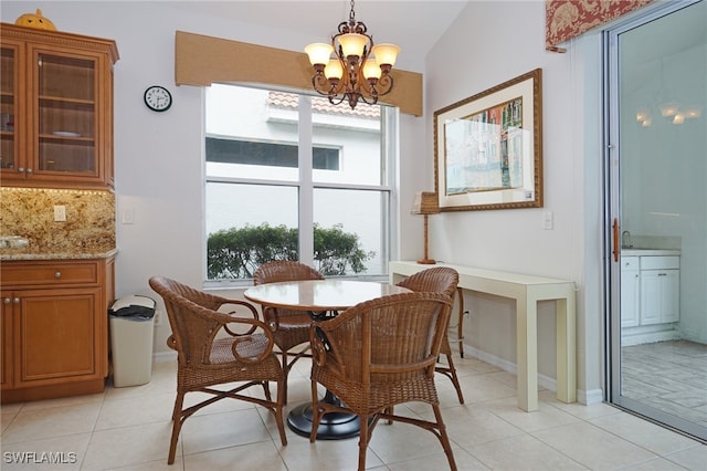 tiled dining area with vaulted ceiling and an inviting chandelier