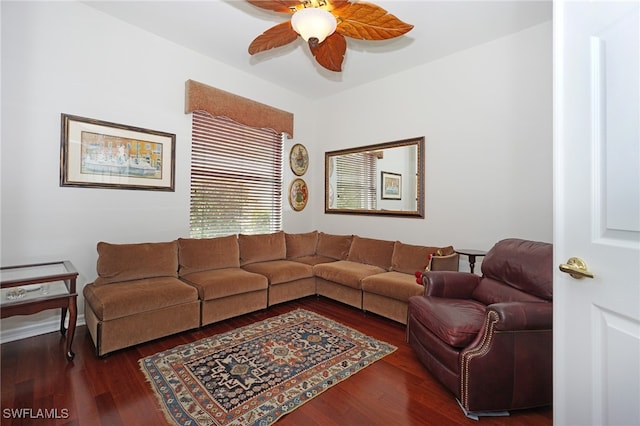 living room featuring ceiling fan and dark wood-type flooring