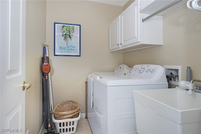 laundry room featuring washer and clothes dryer, light tile patterned flooring, cabinets, and sink