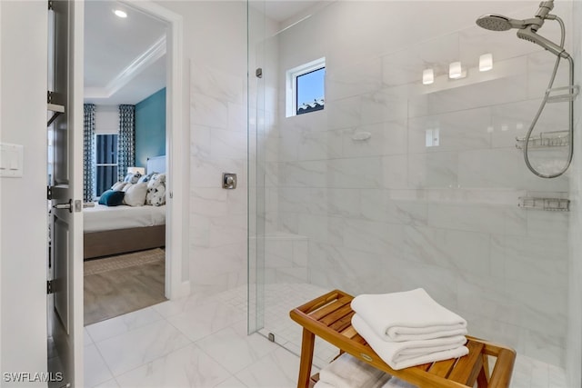 bathroom featuring a tile shower and a raised ceiling