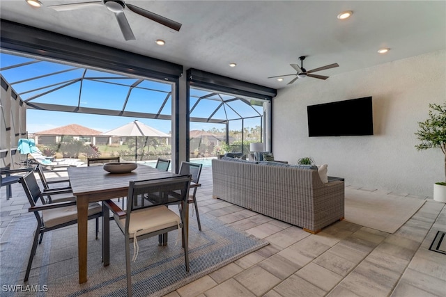 view of patio with outdoor lounge area, glass enclosure, and ceiling fan