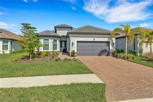 mediterranean / spanish-style home with a front yard and a garage