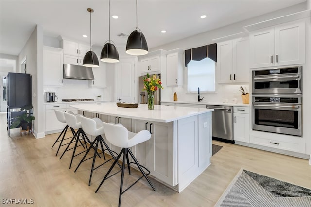 kitchen featuring white cabinets, a kitchen island, and stainless steel appliances