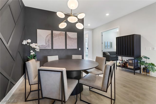 dining space with a chandelier and light hardwood / wood-style floors