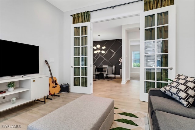 living room featuring a chandelier, french doors, and wood-type flooring