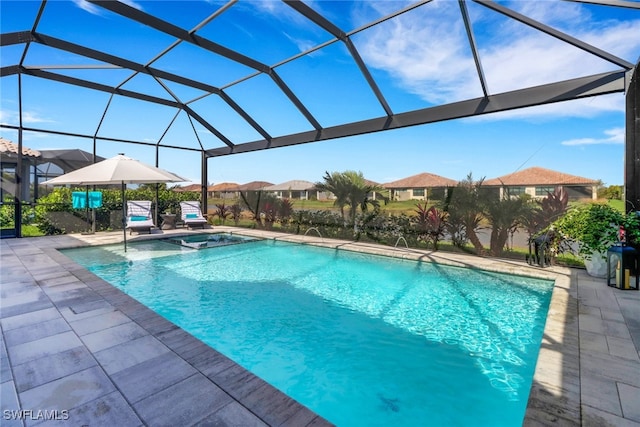 view of pool featuring an in ground hot tub, glass enclosure, and a patio area