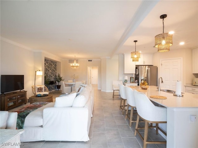 living room featuring tile patterned flooring, sink, a notable chandelier, and beam ceiling