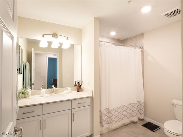 bathroom featuring vanity, tile patterned flooring, toilet, and walk in shower