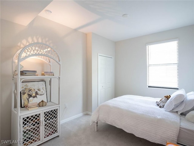 bedroom featuring light carpet and a closet