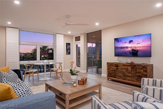 living room with light hardwood / wood-style flooring and ceiling fan