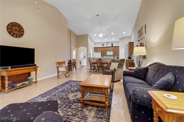 tiled living room featuring ceiling fan and high vaulted ceiling