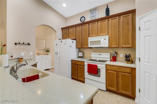 kitchen featuring sink, light tile patterned floors, and white appliances