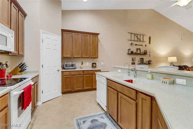 kitchen featuring lofted ceiling, sink, light tile patterned floors, and white appliances