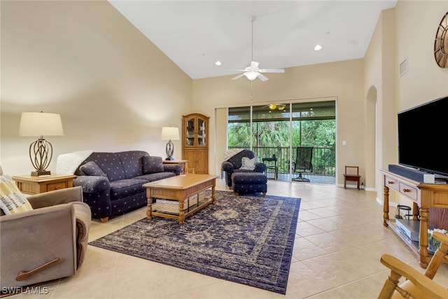 living room featuring ceiling fan, light tile patterned floors, and a high ceiling