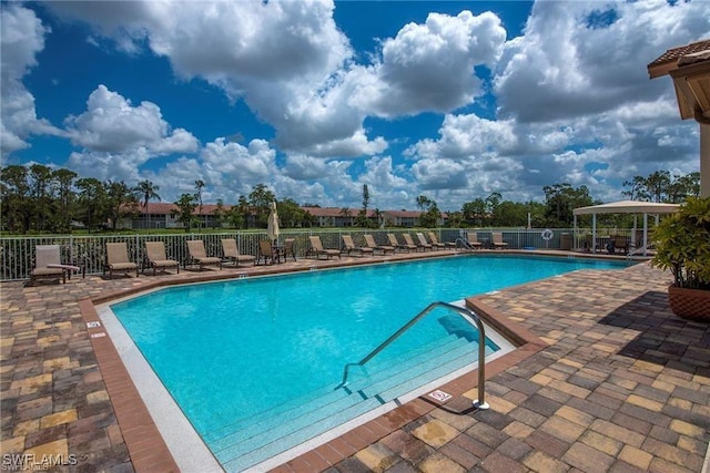 pool featuring fence and a patio