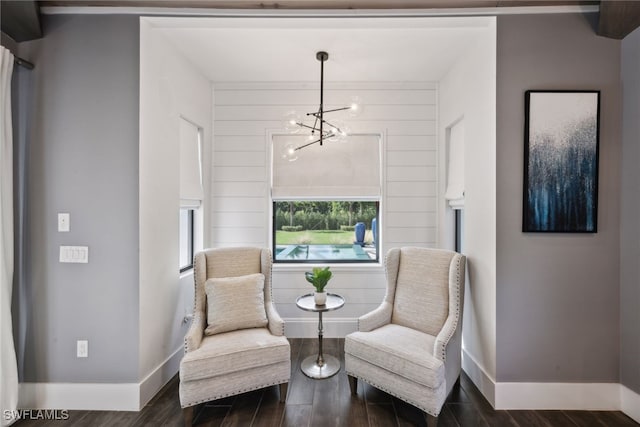 living area with wood walls, dark hardwood / wood-style floors, and a notable chandelier