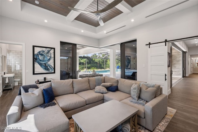 living room featuring dark hardwood / wood-style flooring, a barn door, and wood ceiling