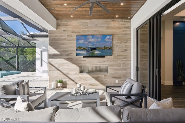 view of patio featuring outdoor lounge area, glass enclosure, and ceiling fan