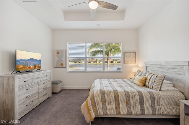 bedroom featuring baseboards, a raised ceiling, carpet, and ceiling fan