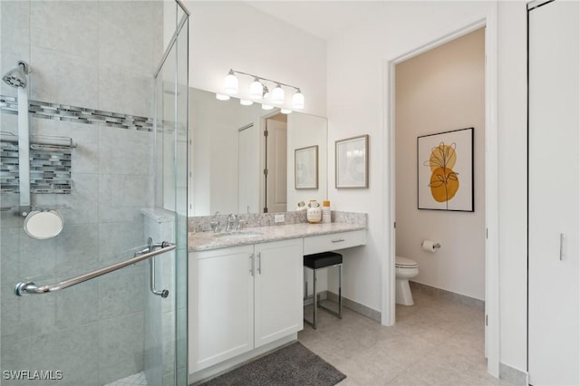 full bath featuring a shower stall, toilet, vanity, and baseboards