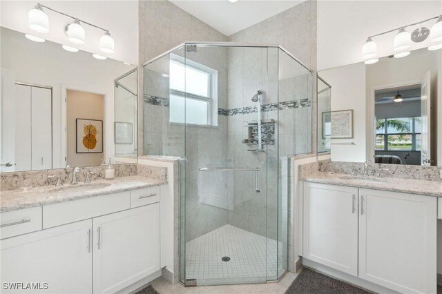 bathroom with vanity, ceiling fan, and a shower with door