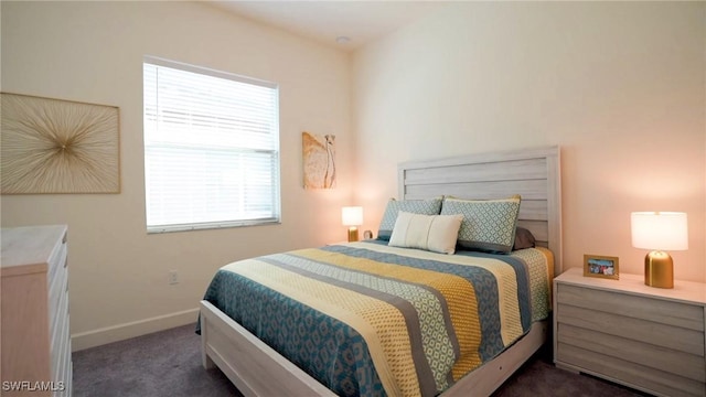 bedroom featuring baseboards and dark colored carpet