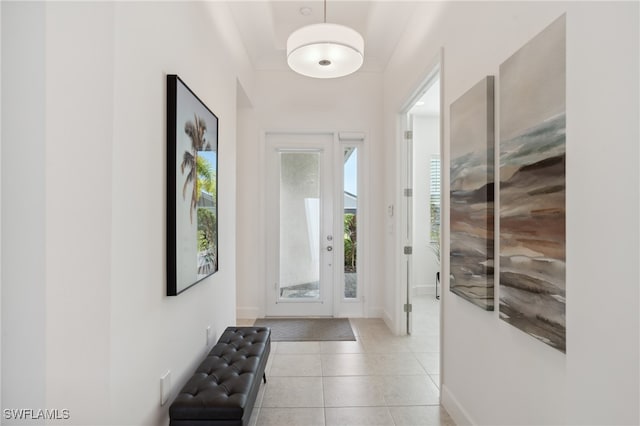 doorway to outside with baseboards and light tile patterned flooring