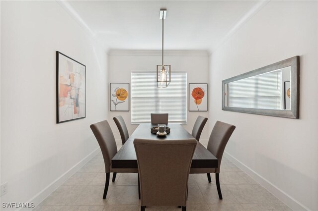 dining area with crown molding, light tile patterned floors, and a chandelier