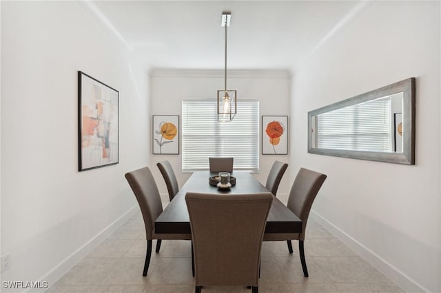 dining space with light tile patterned flooring, a healthy amount of sunlight, baseboards, and ornamental molding