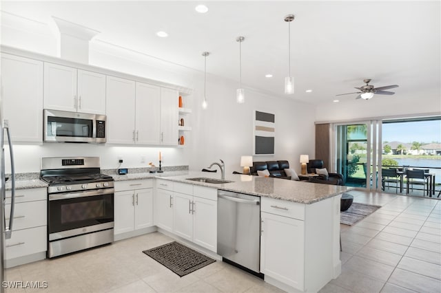 kitchen featuring hanging light fixtures, ceiling fan, appliances with stainless steel finishes, white cabinetry, and kitchen peninsula