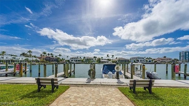 view of dock featuring a water view and a lawn