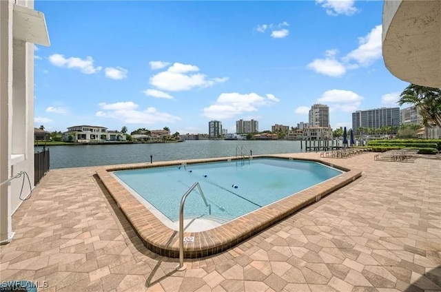 view of pool featuring a water view and a patio