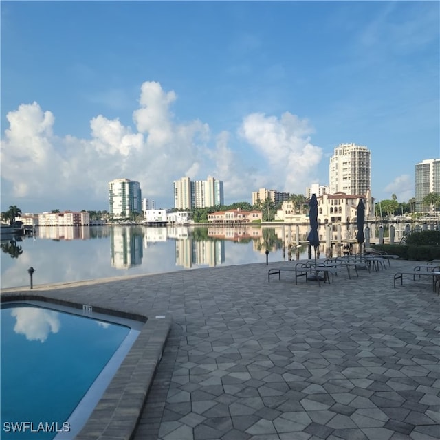 view of swimming pool with a water view and a patio area