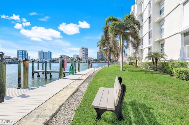 view of dock with a lawn and a water view