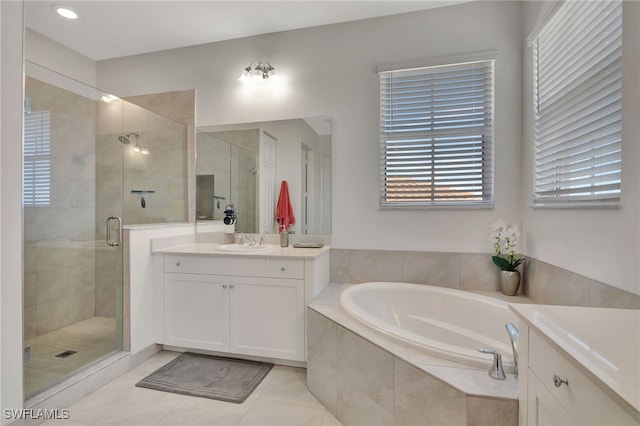 bathroom featuring plus walk in shower, vanity, and tile patterned flooring