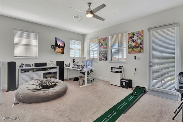 carpeted office space featuring ceiling fan