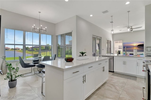 kitchen featuring stainless steel appliances, sink, pendant lighting, a center island, and white cabinetry