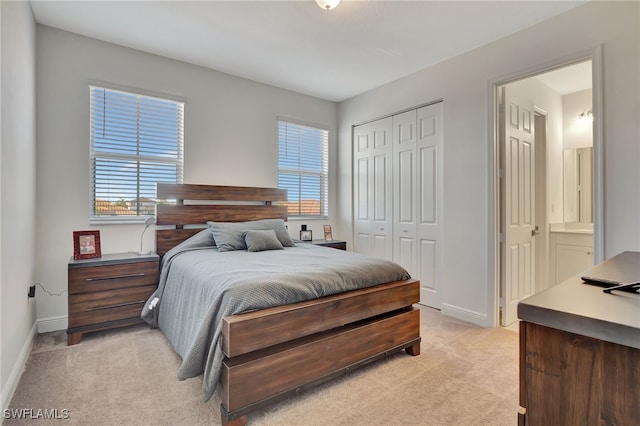 bedroom with light carpet, ensuite bath, and multiple windows