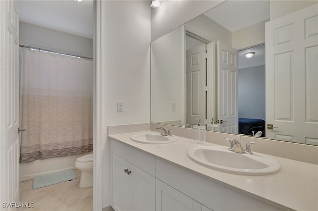 full bathroom featuring tile patterned floors, shower / bath combo with shower curtain, vanity, and toilet