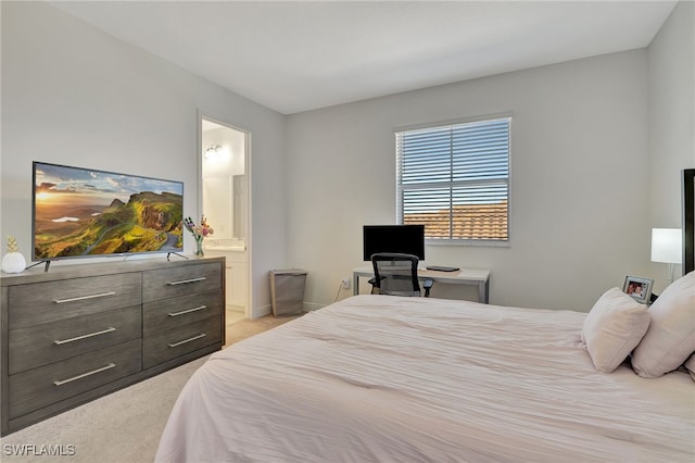 bedroom with connected bathroom and light colored carpet