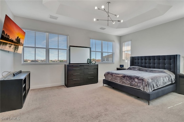 bedroom with a raised ceiling, light carpet, and a notable chandelier