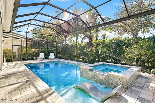 view of swimming pool featuring a lanai, a patio area, and an in ground hot tub