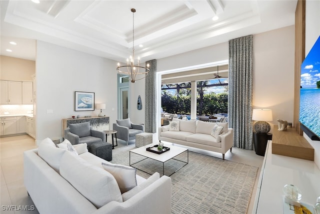 tiled living room featuring a raised ceiling, a towering ceiling, and a notable chandelier