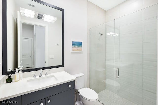 bathroom featuring vanity, toilet, and a shower with door