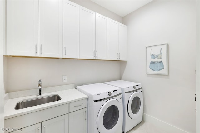 clothes washing area featuring washer and dryer, light tile patterned flooring, sink, and cabinets