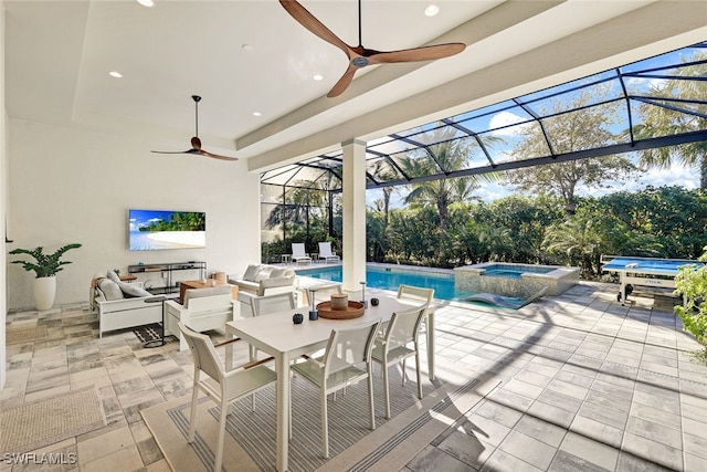 view of patio / terrace featuring ceiling fan, a swimming pool with hot tub, and a lanai